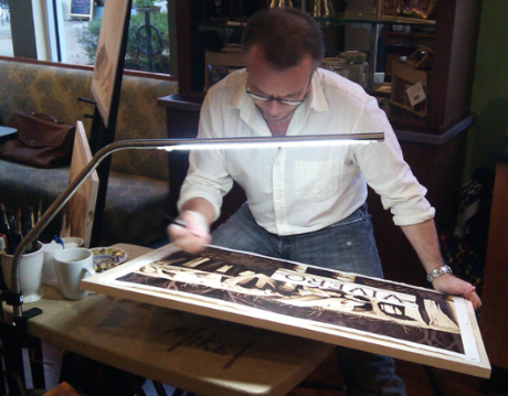 A photo of Steven Mikel painting live at a Barnie's Coffee and Tea location, while working on the painting entitled 'Vivero' - Dark Roast Watercolors, Painting with Coffee